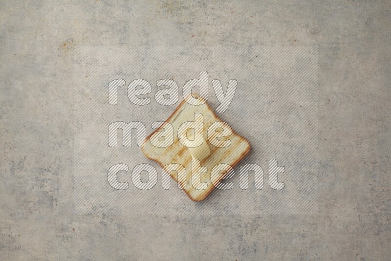 Toasted White Toast slices with a butter curl on a light blue textured background