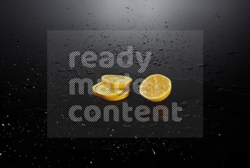 Lemon slices with water drops, and droplets on black background