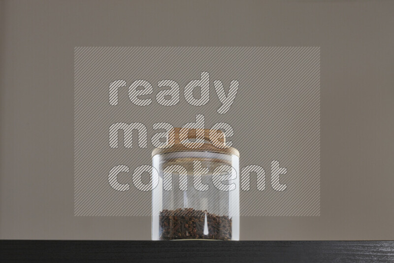 Dried basil in a glass jar on black background