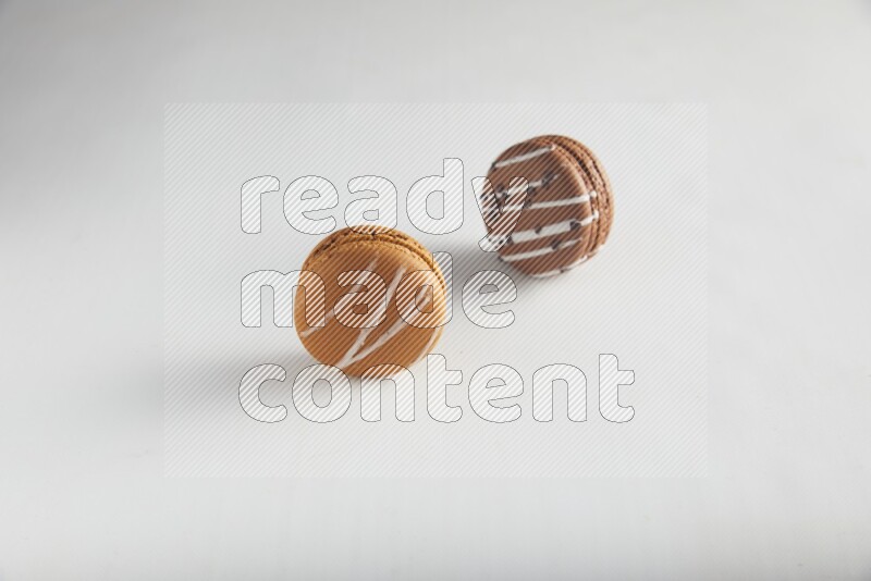 45º Shot of of two assorted Brown Irish Cream, and Brown white Chocolate Caramel macarons on white background