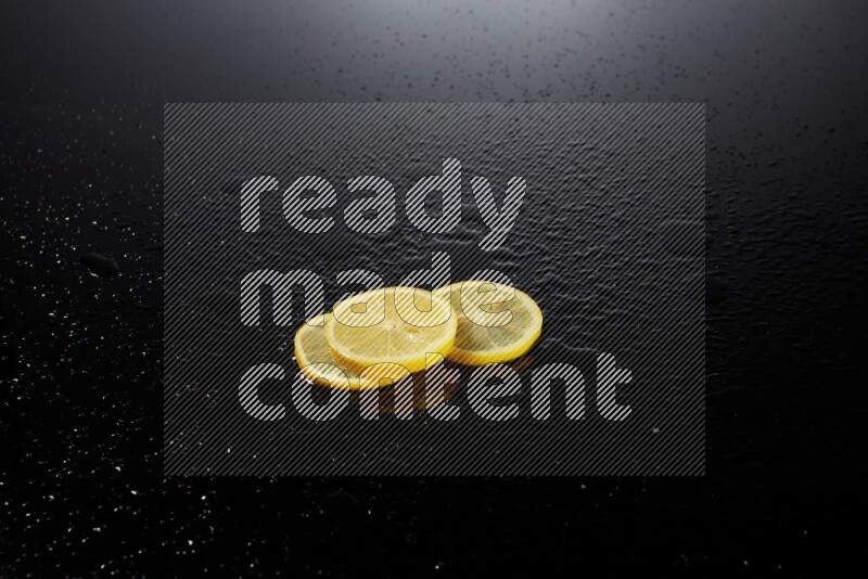 Lemon slices with water drops, and droplets on black background