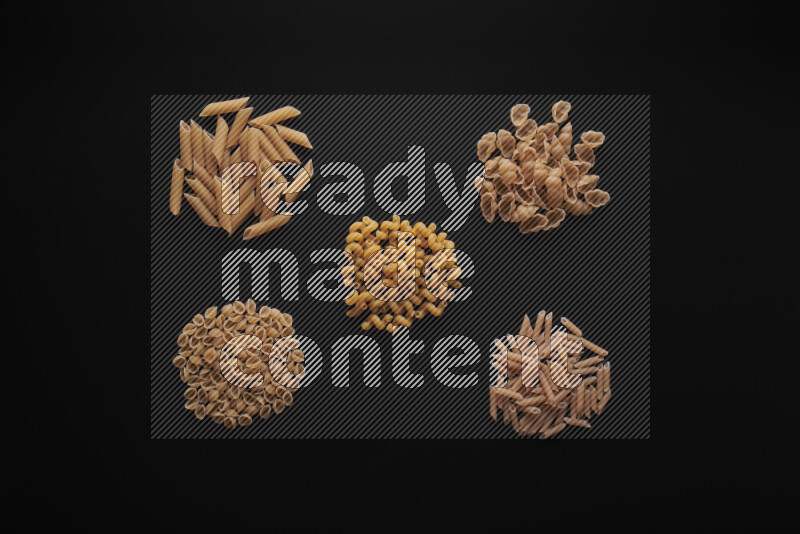 Different pasta types in bunches on black background