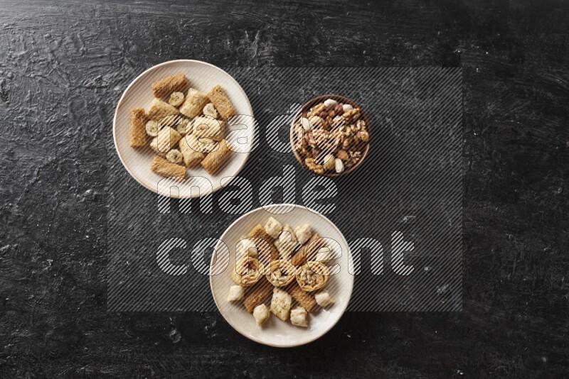 Oriental sweets in pottery plates with nuts in a dark setup