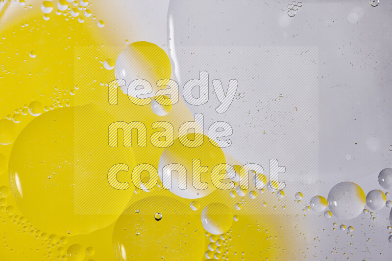 Close-ups of abstract oil bubbles on water surface in shades of white and yellow