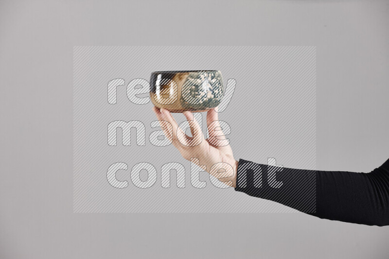 A woman in black abaya holding different pottery essentials in different positions