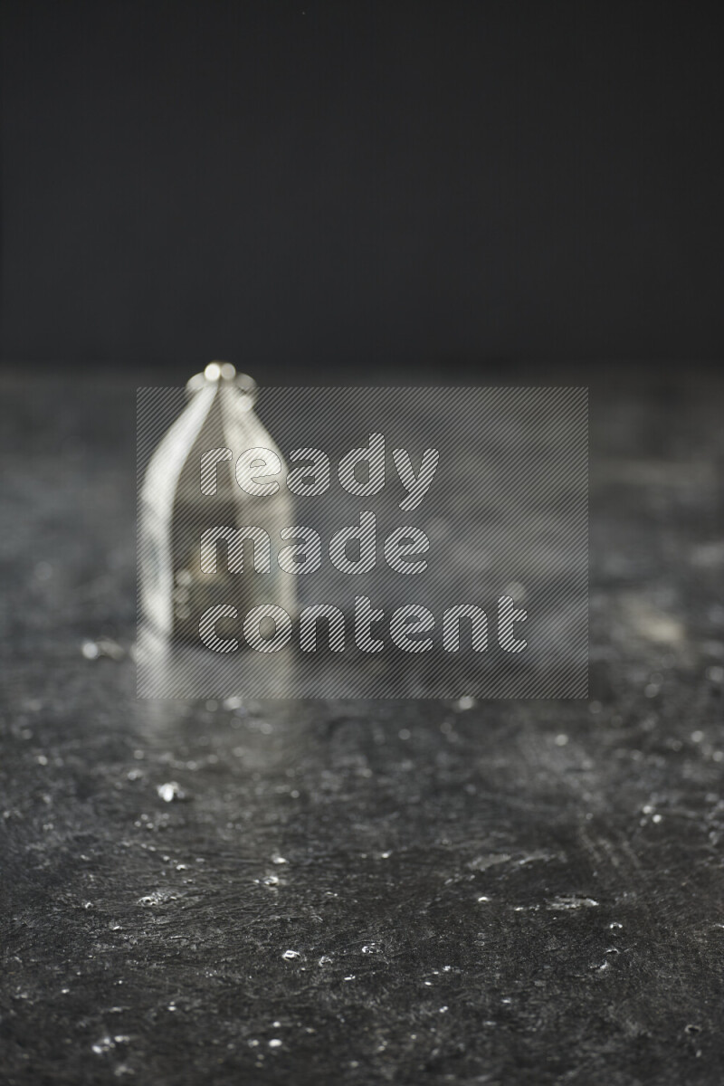 A lantern placed on a textured black background