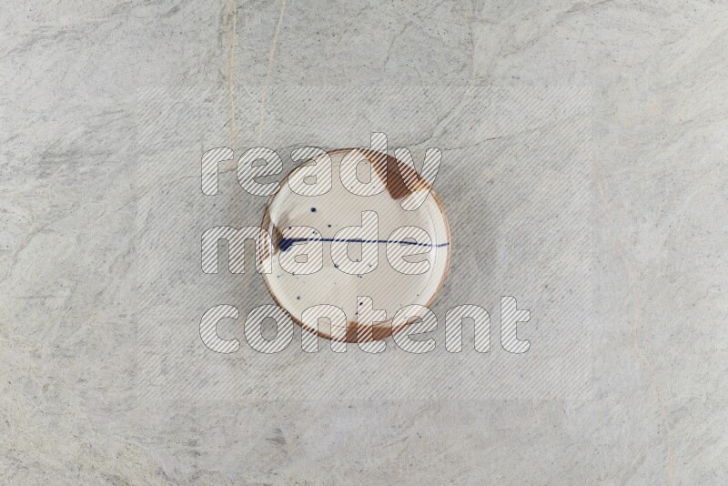 A multicolored pottery plate on grey marble background