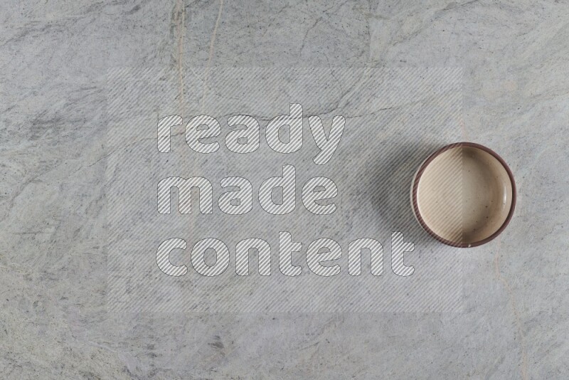 وعاء فرن فخاري متعدد الألوان على خلفية من الرخام الرمادي