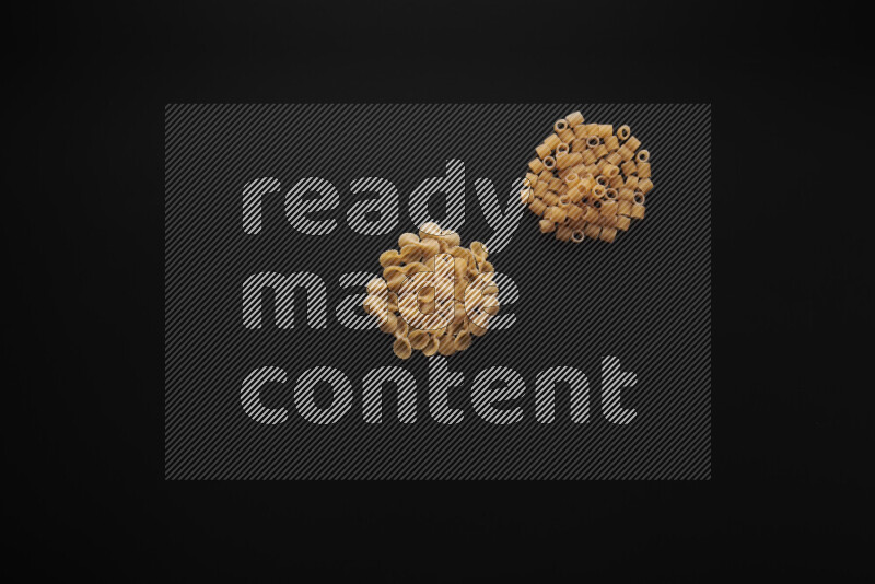 Different pasta types in bunches on black background