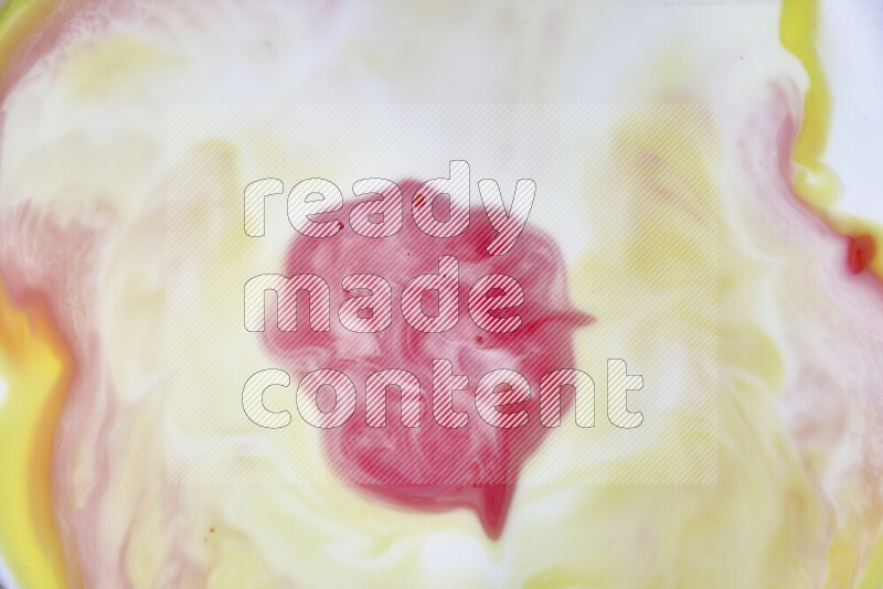 A close-up of abstract swirling patterns in yellow, red and white