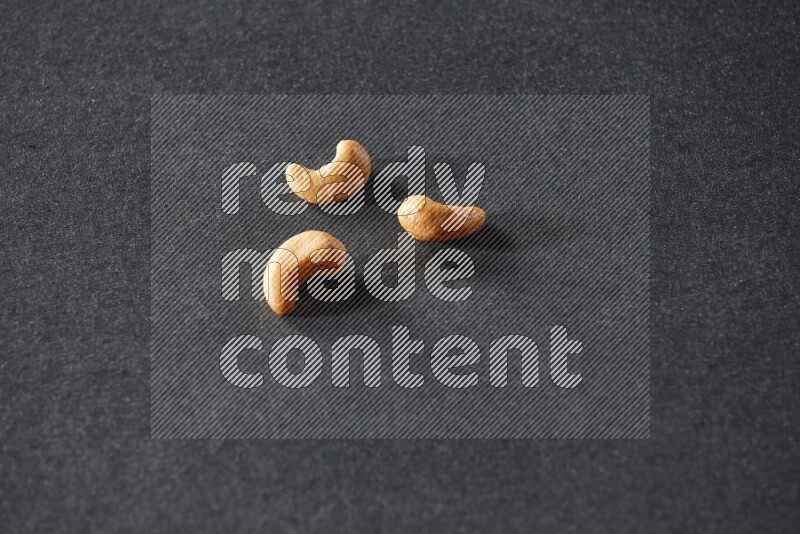 3 cashews on a black background in different angles