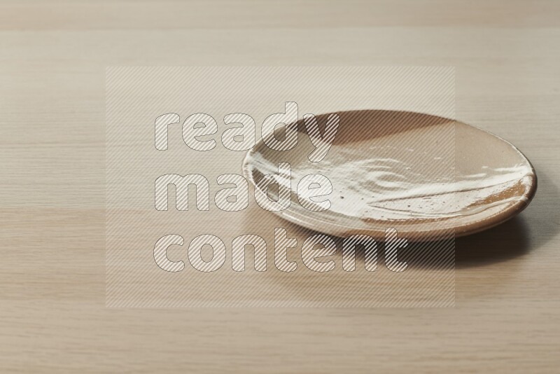 A multicolored pottery plate on light wooden background