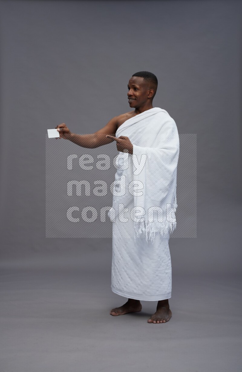 A man wearing Ehram Standing holding ATM card on gray background