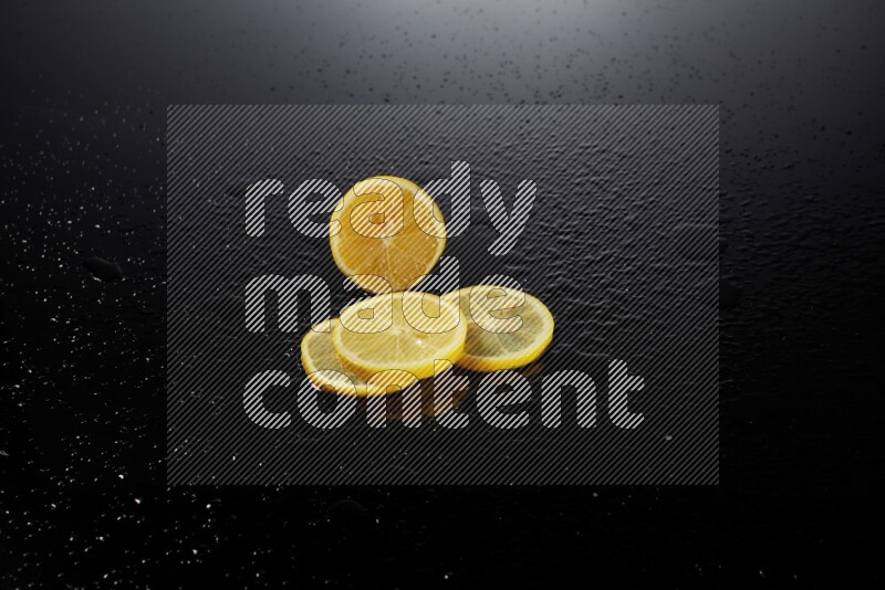 Lemon slices with water drops, and droplets on black background