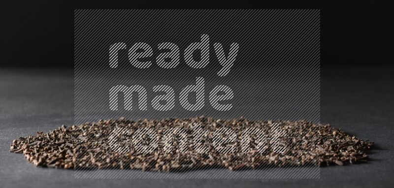 Cloves spread on black flooring