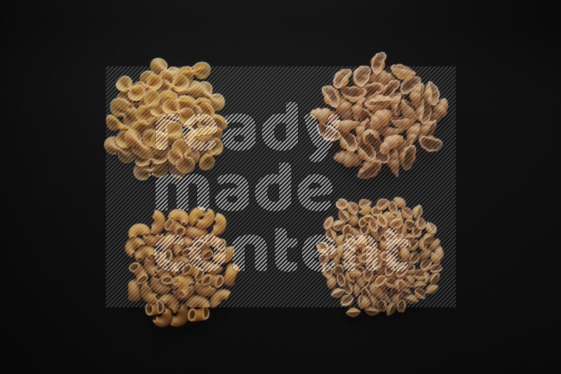Different pasta types in bunches on black background