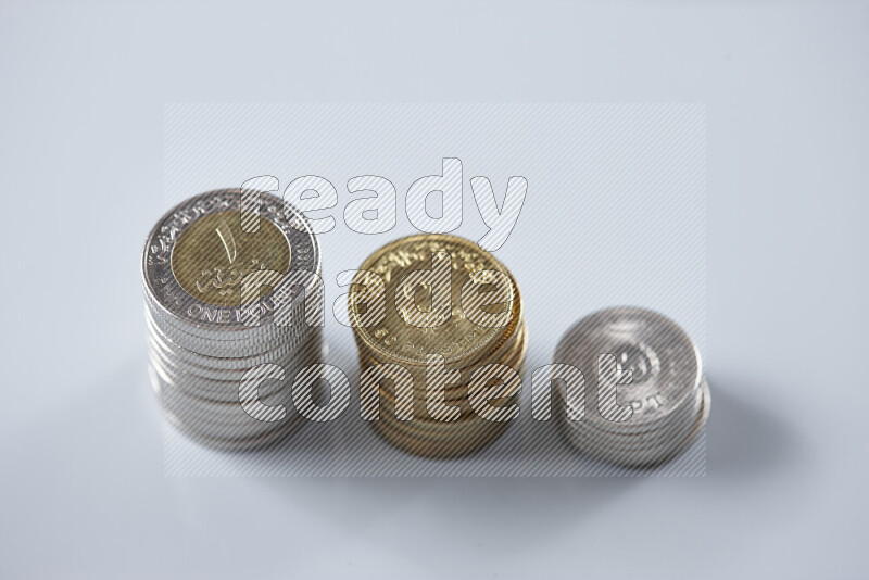 A close-up of scattered mixed Egyptian coins such as One pound, 50 and 25 piasters on grey background