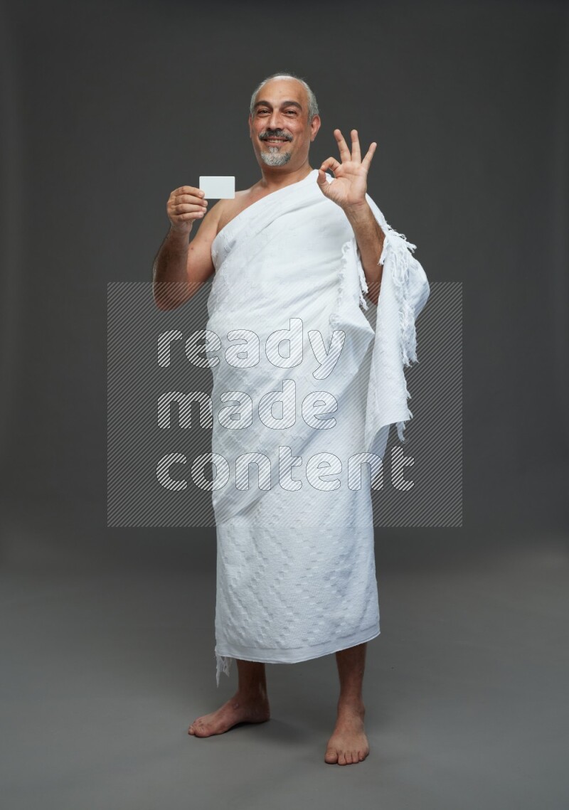 A man wearing Ehram Standing holding ATM card on gray background