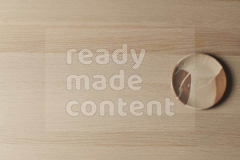 A multicolored pottery plate on light wooden background