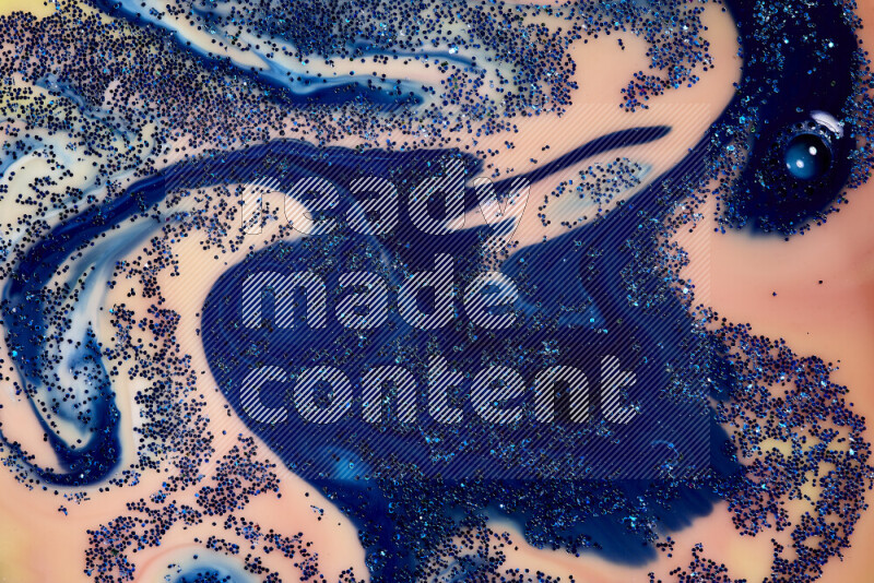 A close-up of sparkling blue glitter scattered on swirling blue and orange background