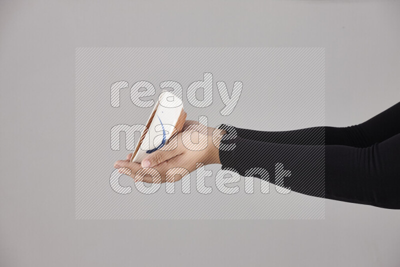 امرأة ترتدي عباءة سوداء تحمل أدوات فخارية مختلفة في أوضاع متعددة