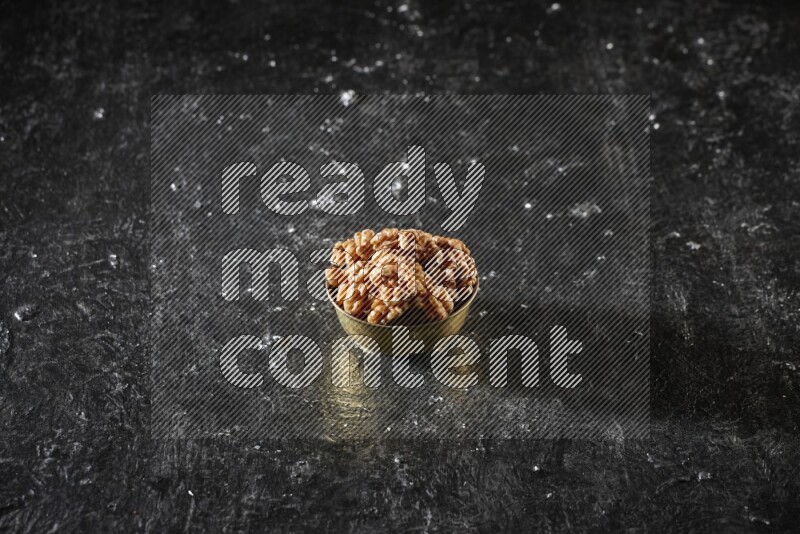 Nuts in a metal bowl in a dark setup