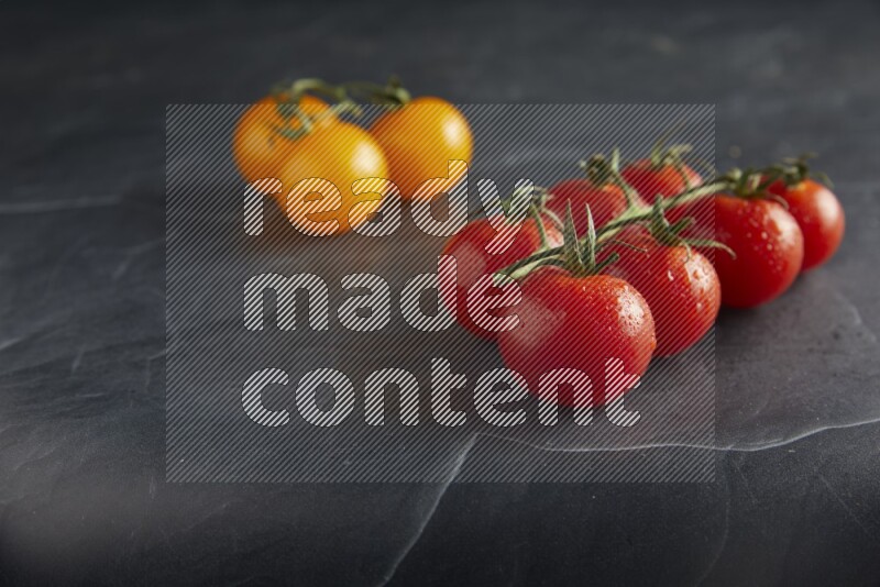 Mixed cherry tomato veins on a textured black slate background 45 degree