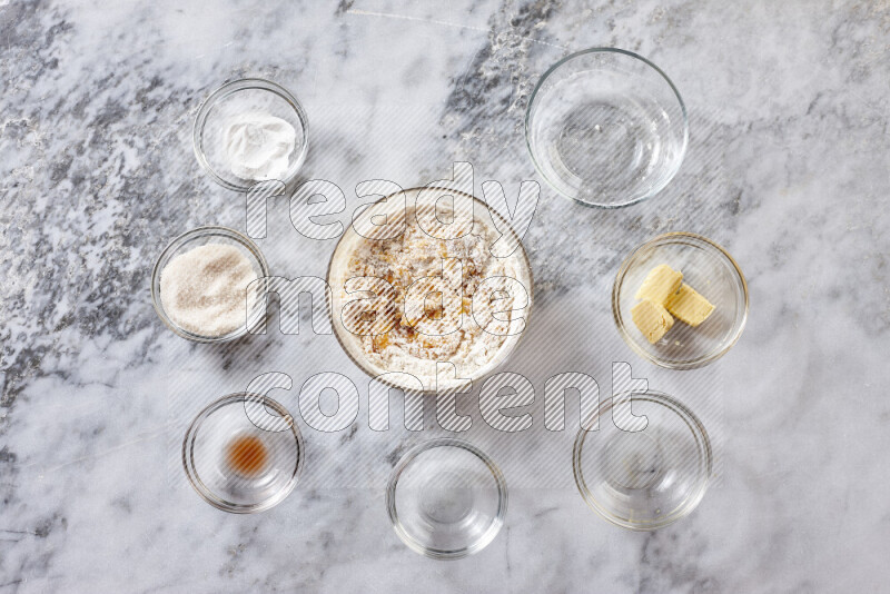 Cookies step by step with its ingredient, flour, butter, brown sugar, egg, vanilla extract, white sugar, chocolate chips and baking soda on grey marble background