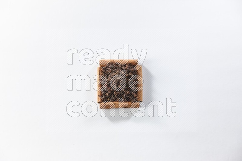 A single square of cinnamon sticks full of cloves on white flooring