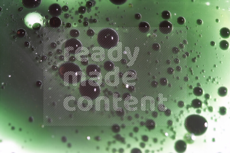 Close-ups of abstract green watercolor drops on oil Surface on white background