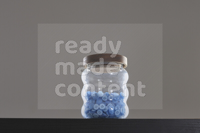 Buttons in a glass jar on black background