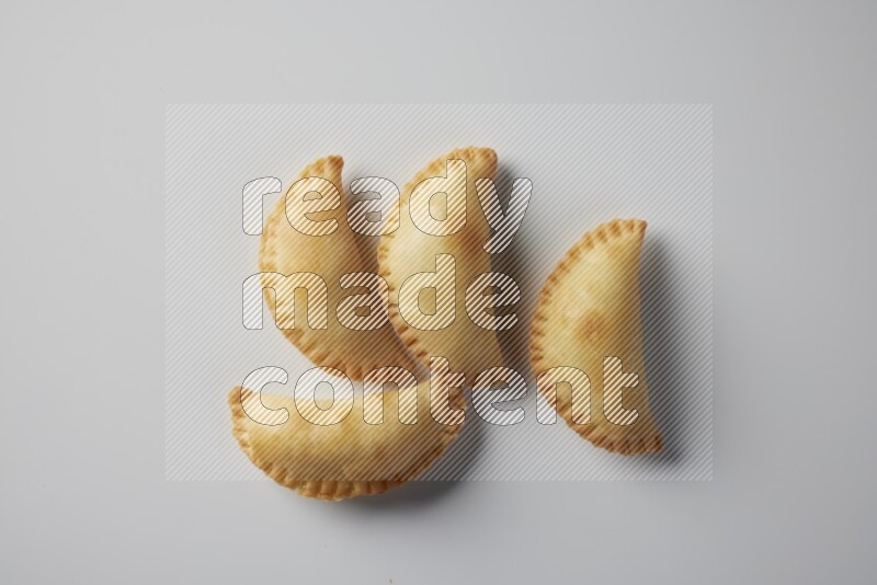 Four fried sambosa from a top angle on a white background