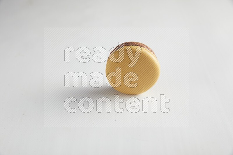 45º Shot of Yellow and Brown Chai Latte macaron on white background