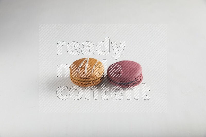 45º Shot of of two assorted Brown Irish Cream, and Red Cherry macarons on white background
