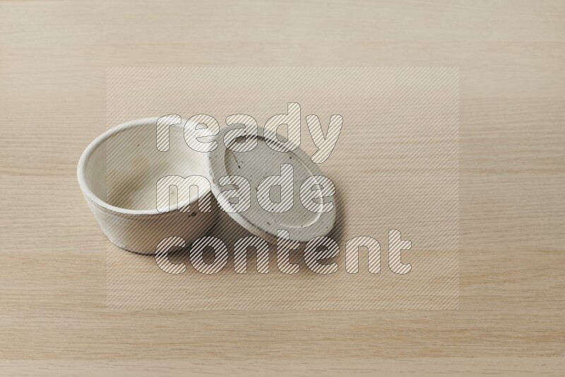 A white pottery bowl on light wooden background
