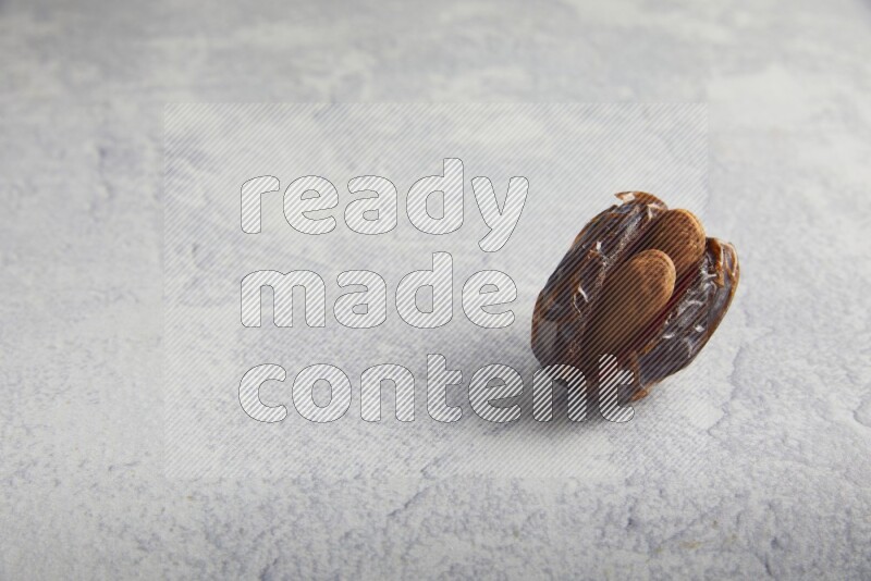 almond stuffed madjoul date on a light grey background