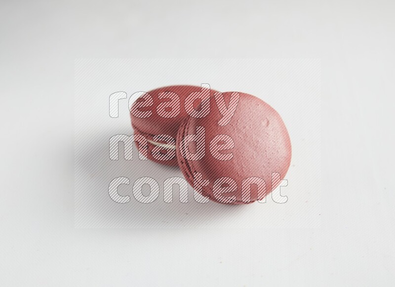 45º Shot of two Red Velvet macarons on white background