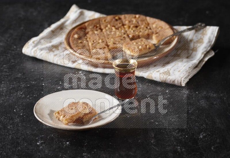 Basbousa with tea in a dark setup