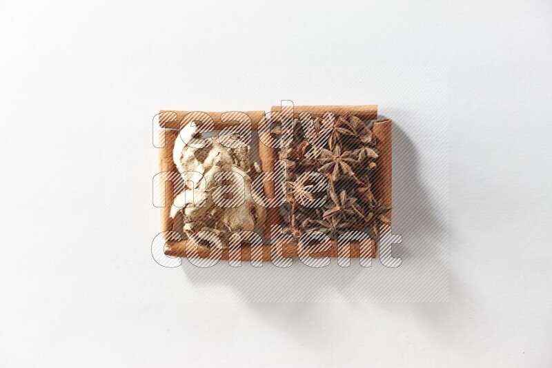 2 squares of cinnamon sticks full of star anise and dried ginger on white flooring