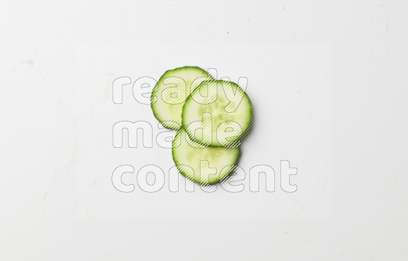three cucumber slices on white background