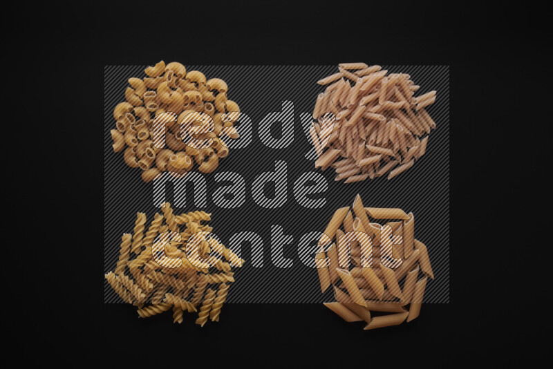 Different pasta types in bunches on black background