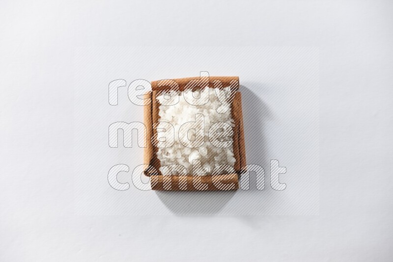 A single square of cinnamon sticks full of salt on white flooring
