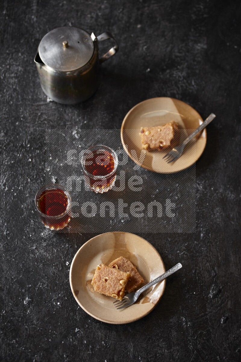 Basbousa with tea in a dark setup