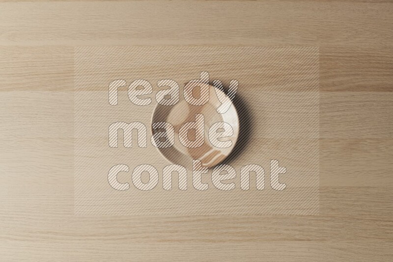 A multicolored pottery plate on light wooden background