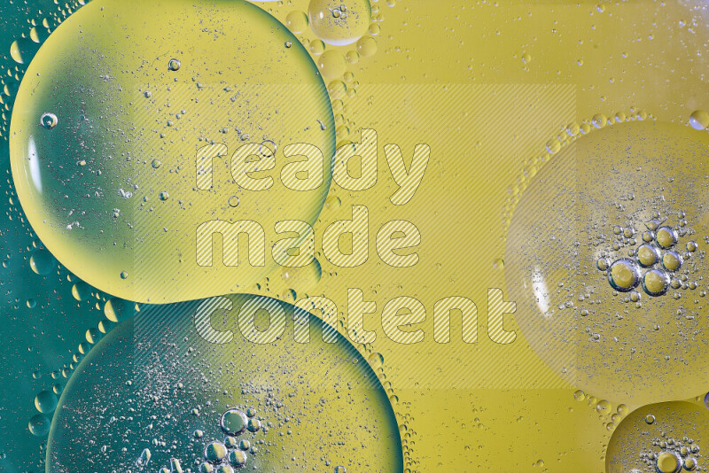 Close-ups of abstract oil bubbles on water surface in shades of green and yellow