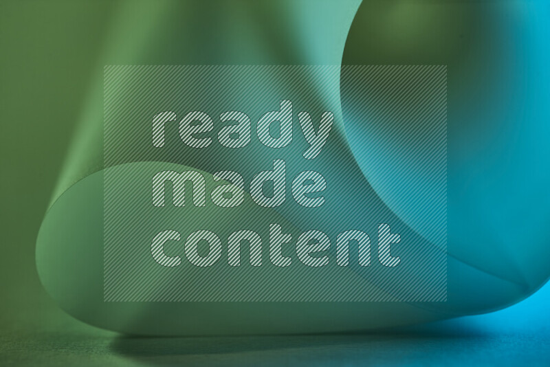 An abstract art piece displaying smooth curves in green and blue gradients created by colored light