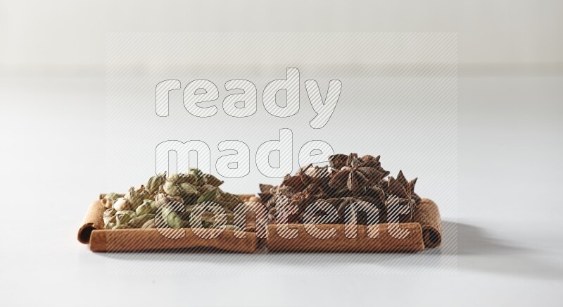 2 squares of cinnamon sticks full of star anise and cardamom on white flooring