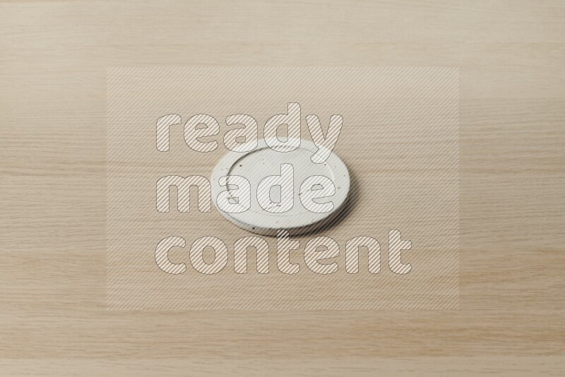 A pottery coaster on light wooden background