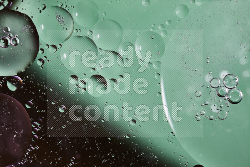 Close-ups of abstract oil bubbles on water surface in shades of black and green