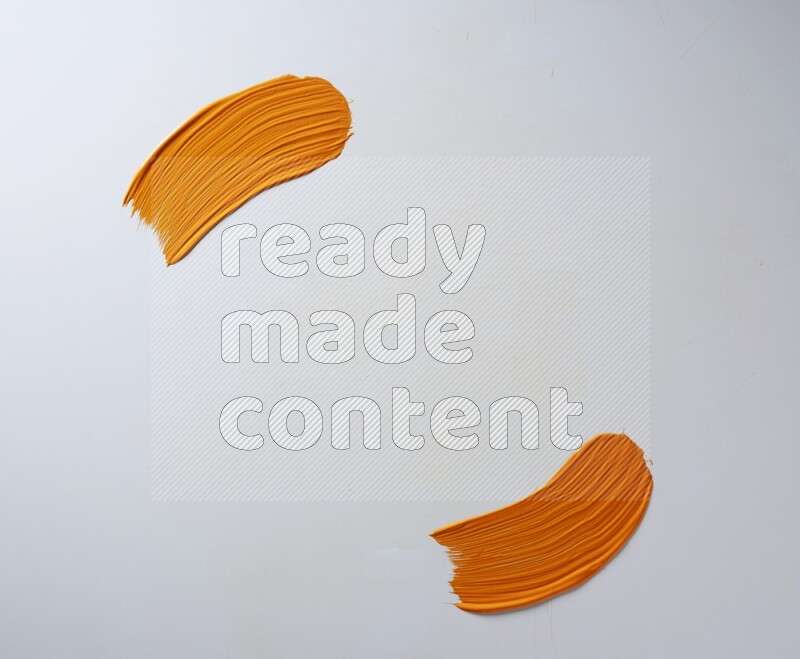 An orange curved painting brush stroke on a white background